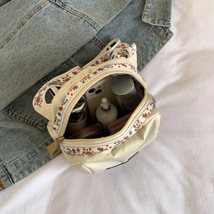 Waterproof nylon crossbody bag in cream white with embroidered strap and spacious interior