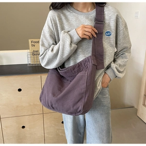 Detail view of large purple cotton canvas crossbody bag with wide shoulder strap design