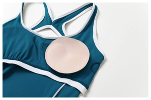 Detailaufnahme des tiefseeblauen Yoga-Bodysuits mit weißem Rand und herausnehmbaren Pads