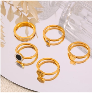 Detailed close-up of a five-piece set of gold-plated rings with tree of life and CZ accents