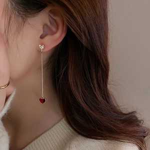 Detailed view of asymmetric heart chain earring with red enamel and pavé crystals