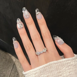 Macro view of crystal 3D butterfly nail art with a sparkling zircon ring on hand