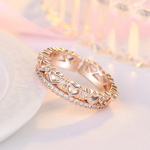 Macro shot of rose gold open ring featuring hollow hearts and sparkling zircon stones