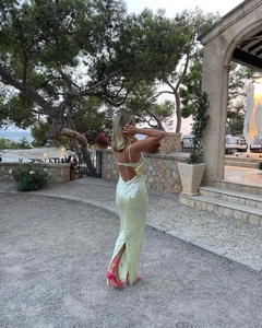 Detail of light green backless sequin dress featuring slim straps and a high back slit