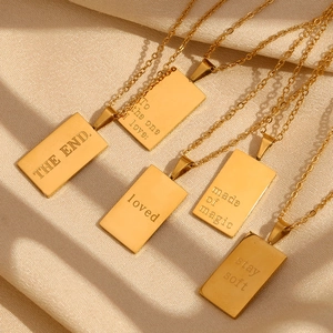 Detailed view of 18K gold plated square pendants with engraved quotes on gold chains