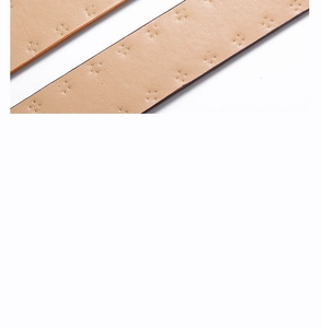 Detail of light brown faux leather belt with vintage cross stitching and textured finish
