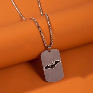 Detail of silver rectangular stainless steel tag pendant with yellow bat on orange background