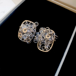 Macro detail of 18k gold plated silver stud earrings with crystals in a jewelry box