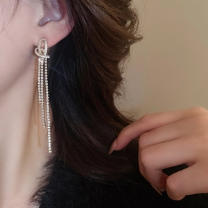 Detail of elegant gold heart tassel earrings with sparkling rhinestones on model side profile