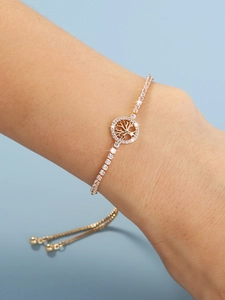 Close-up of a gold tree of life bracelet with cubic zirconia on a female wrist