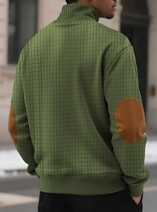 Detail of green men's stand collar sweater with brown elbow patches and quilted texture