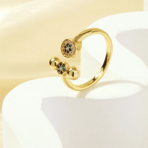 Detail of 18K gold-plated X-shape open ring with blue and clear zircon stones on stand