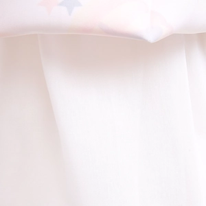 Detailed close-up of white textile fabric with colorful star prints for girls dress