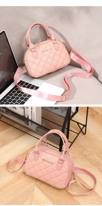 Detailed view of pink quilted handbag with gold hardware and wide adjustable strap