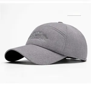 Close-up of vintage scroll embroidery on a light gray cotton twill baseball cap