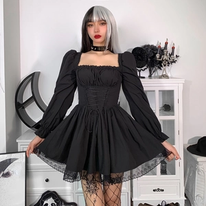 Detalle de vestido gótico negro con mangas abullonadas, encaje y lazos en cintura