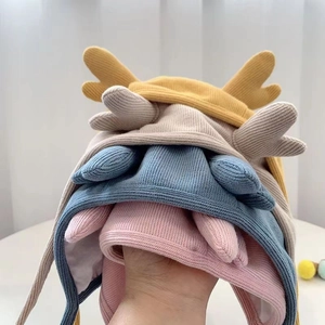 Detail of soft knitted baby hats with antlers in yellow, grey, blue and pink colors
