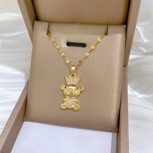 Luxury gold titanium teddy bear necklace with crown and crystals in a jewelry box