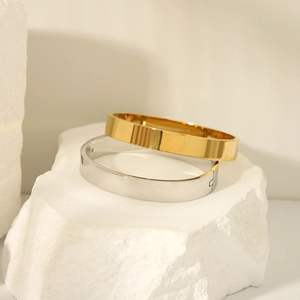Macro view of gold and silver mirror-polished bangles with side clasp details