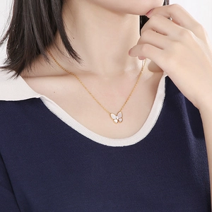 Detail shot of a butterfly pendant necklace with white shell and center diamond crystal
