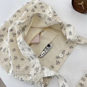 Vue détaillée de l'intérieur du sac en toile fleurie avec poche zippée et fermoir