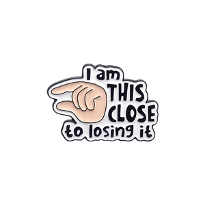 Spilla in smalto divertente con gesto della mano e testo I am this close to losing it su bianco