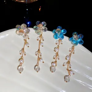 Crystal flower tassel earrings with freshwater pearls on a white shell tray