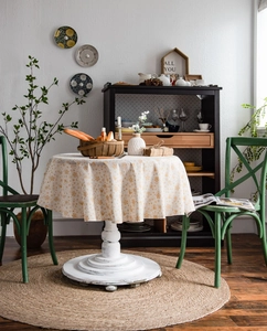 Detail of round festive linen tablecloth with gold patterns and snowflake prints