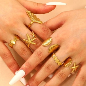 Gold ocean themed ring set featuring starfish and seashell designs on satin background