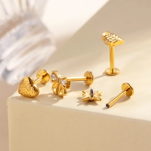 Titanium piercing jewelry set with gold star, moon, bow, and engraved heart stud earrings