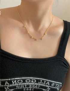 Close-up of elegant gold choker necklace with five sparkling zircon pendants on model