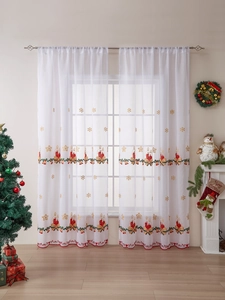 Detail showing white Christmas sheer curtain with gold snowflake and candle embroidery