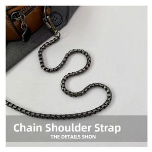 Macro shot of gunmetal chain strap and textured brown leather on a crossbody bag