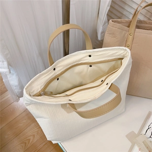 Top view of minimalist striped cotton tote bag with leather handles and inner zipper pocket