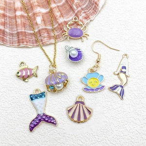 Flat lay of colorful enamel ocean pendants with starfish and shells for DIY jewelry