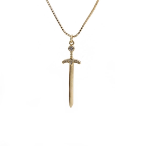 Macro detail of gold cross sword pendant with cubic zirconia stones on box chain