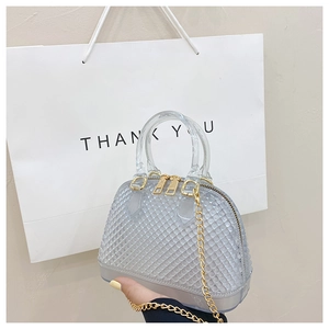 Detail of transparent PVC jelly bag with rivet texture and gold chain strap