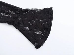 Close-up of elegant black floral lace trumpet sleeve cuff with delicate sheer patterns