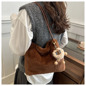 Detailed side view of brown faux fur tote bag with cute plush lamb charm on a person
