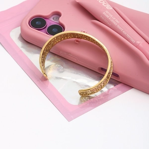 Texture de maille dentelle sur bracelet jonc en acier doré vue de dessus en gros plan