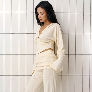 Side view of beige two-piece lounge set with zip-up hoodie and high-waist pants