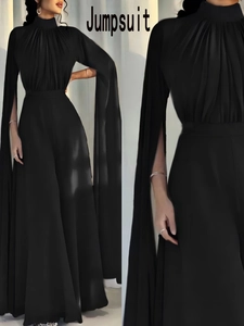 Detail of elegant black jumpsuit featuring dramatic cape sleeves and pleated neckline