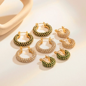 Detail showing three sizes of 18k gold earrings with green and white zircon stones