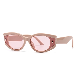 Modieuze ovale kattenoog zonnebril met nude roze montuur en metalen klinknagels voor dames