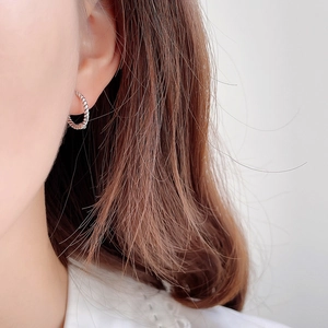 Close-up of model wearing 925 sterling silver twisted rope hoop earrings in silver