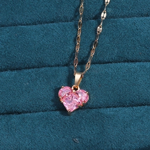 Pink heart-shaped gem necklace in a navy blue velvet jewelry box with rose gold chain