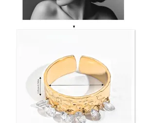Detail of 18K gold stainless steel ring with hammered texture and hanging zircons