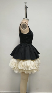 Detail of multi-layered white chiffon petal skirt with black sleeveless bodice contrast