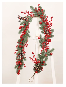 Detail of Christmas berry garland with pine needles and red-black plaid bows
