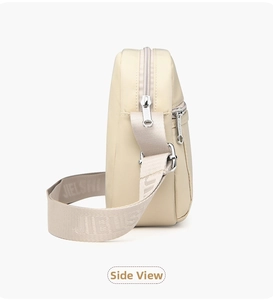 Side view of beige nylon crossbody bag featuring branded wide shoulder strap and zippers
